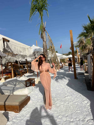 woman in beige flowy dress on beach woman in beige flowy dress on beach