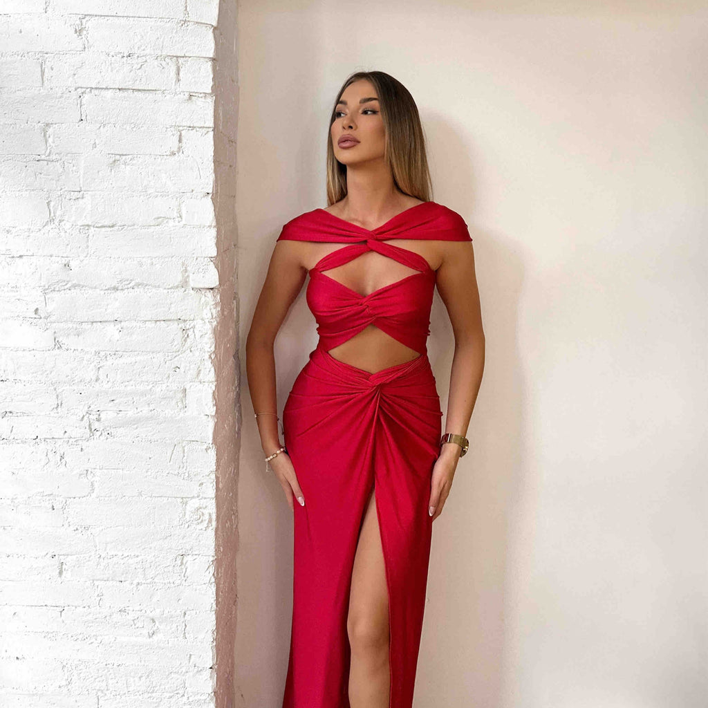 woman in red cutout dress standing near white wall woman in red cutout dress standing near white wall