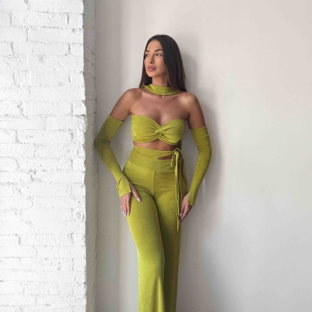 woman wearing green two piece outfit with crop top and high waisted pants woman wearing green two piece outfit with crop top and high waisted pants