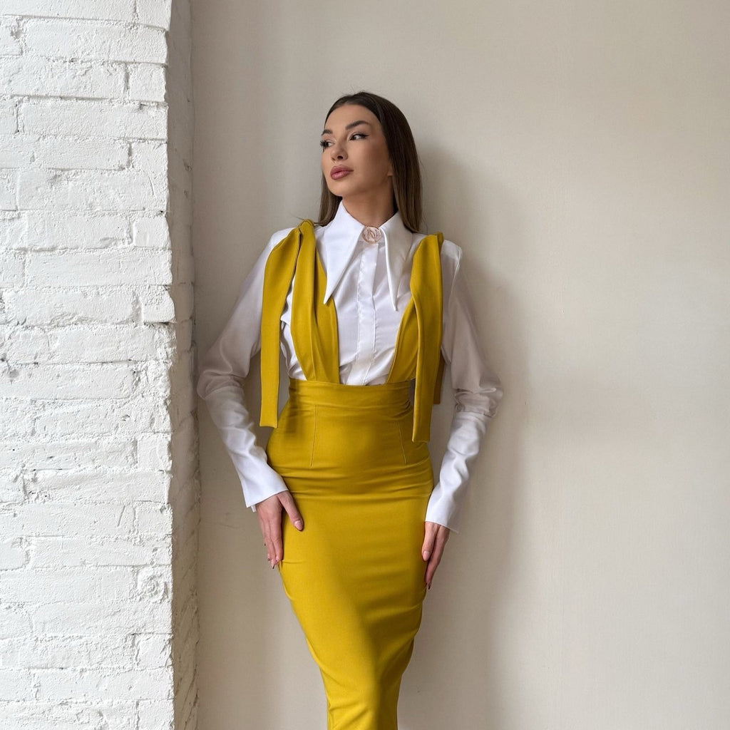 yellow dress over white shirt against textured wall yellow dress over white shirt against textured wall