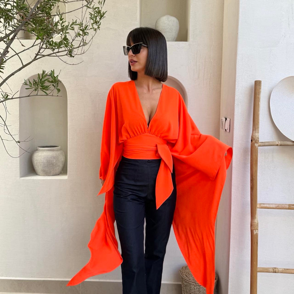 orange dress with black pants and sunglasses orange dress with black pants and sunglasses