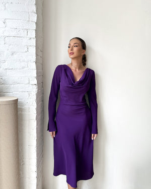 purple long sleeve dress against white wall