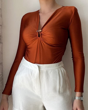 burnt orange top with white pants