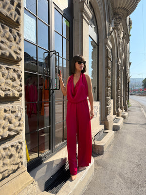 woman in pink sleeveless jumpsuit outside storefront