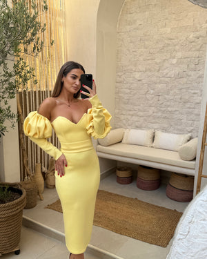 woman in yellow off the shoulder dress taking a selfie