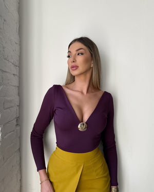 purple long sleeve dress with deep v neck and gold skirt