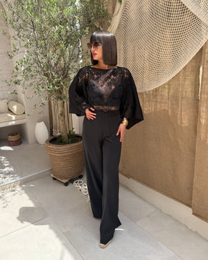 woman in black lace top and trousers in outdoor setting