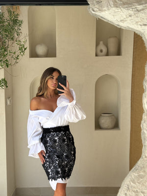 woman in ruffled off shoulder dress with lace skirt taking mirror selfie