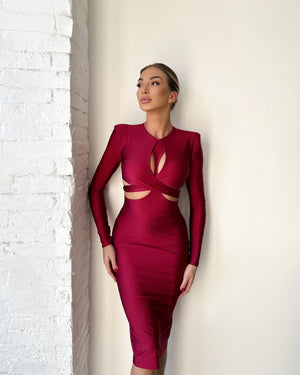 sleek red cutout dress against white wall