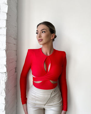 woman wearing red cutout top and beige pants