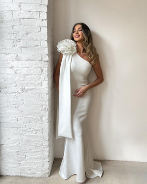 woman in one shoulder white dress with floral detail