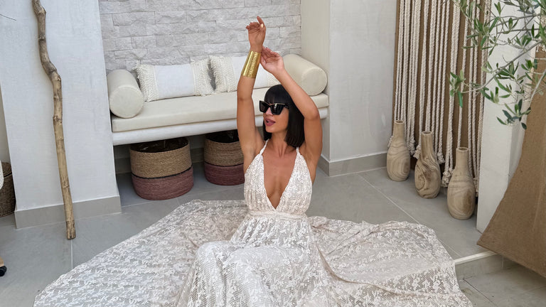 woman in sleeveless white lace dress sitting on floor