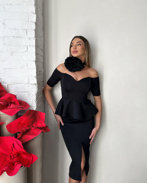 woman in black off shoulder dress standing near red decorations