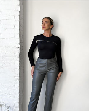 woman in black top and gray pants standing indoor