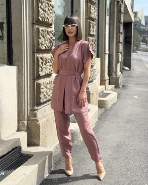 woman in pink outfit standing on street