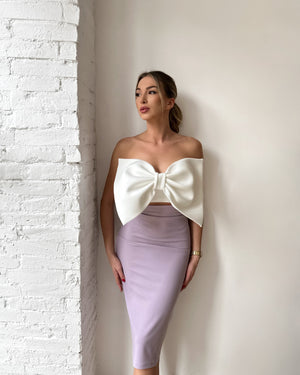woman in white strapless bow top and lavender pencil skirt