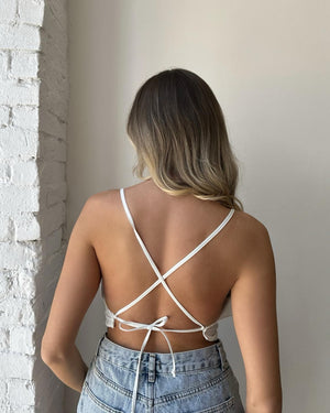 back view of white cross strap top and jeans