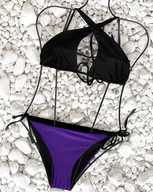 black and purple bikini on white pebbles