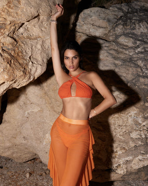 orange two piece outfit in rocky setting