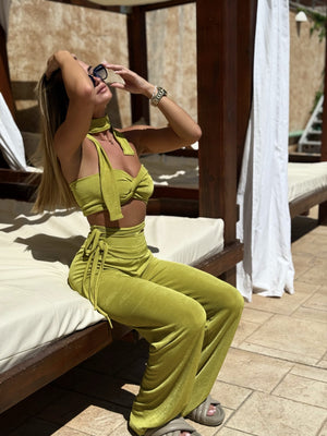 woman in yellow two piece outfit sitting on daybed