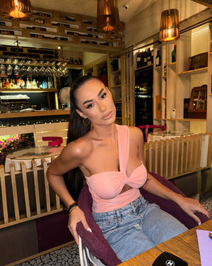 woman in peach top sitting in chic restaurant