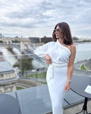 white one shoulder dress on woman overlooking cityscape