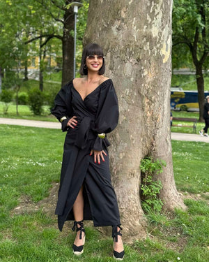 woman in black dress posing outdoors