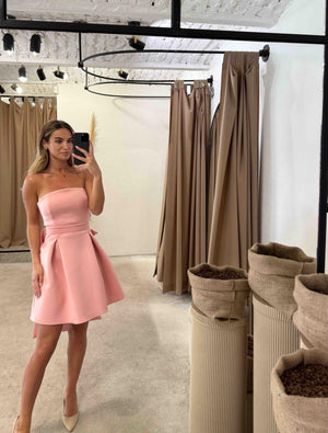 woman wearing pink sleeveless dress in clothing store