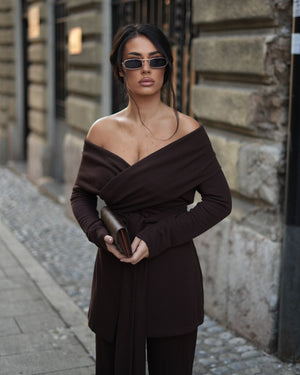 woman in brown off shoulder dress with clutch and sunglasses street style