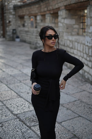 woman wearing black dress and sunglasses holding coffee cup