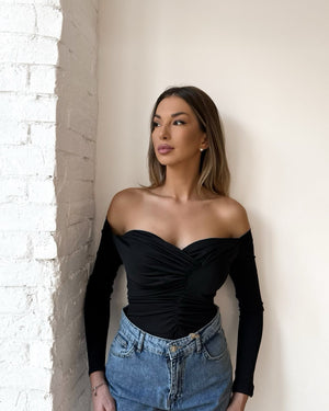 woman wearing off shoulder black top and jeans