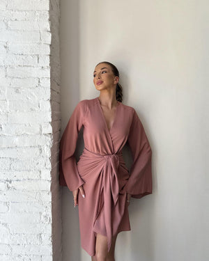 elegant woman in dusty rose wrap dress