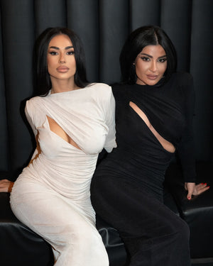 two women wearing stylish dresses one white one black