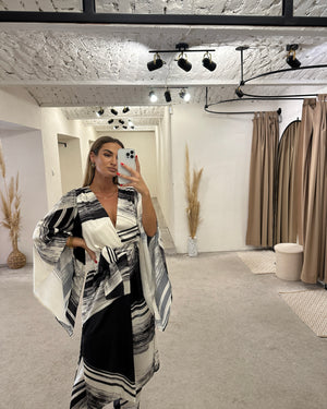 black and white patterned dress with bell sleeves in boutique dressing room