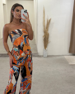 woman wearing colorful strapless jumpsuit taking selfie