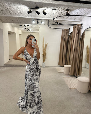 woman in black and white floral dress in fitting room