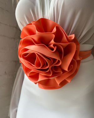 white dress with orange ruffled flower detail