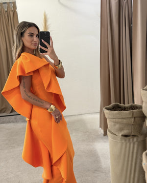 woman wearing vibrant orange dress in fitting room