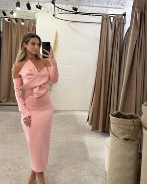 woman wearing pink off shoulder midi dress in dressing room