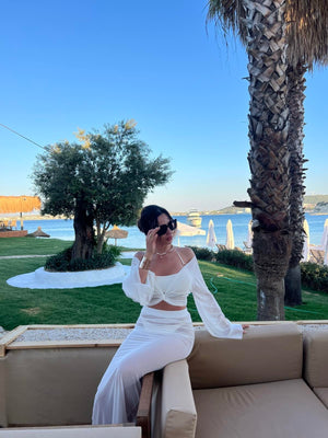 woman in white off shoulder dress by the beach