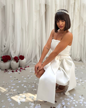 woman in white dress with large bow and headband