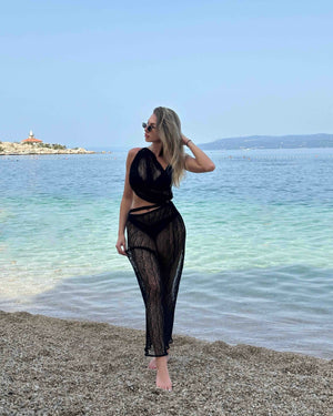 black mesh beach dress on a sandy shore