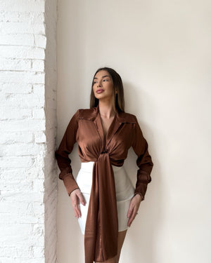 model in brown silk tie front blouse and white skirt