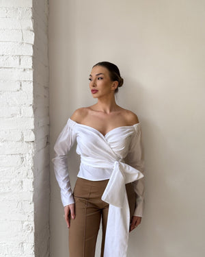 woman in off shoulder white top and tan pants