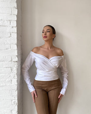 woman in off shoulder white top and brown pants