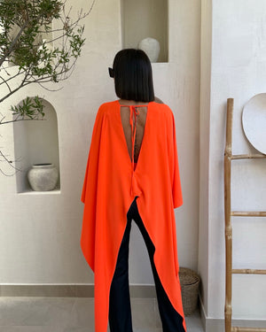 woman wearing orange cape dress back view