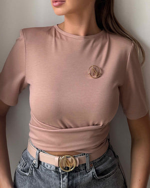 woman wearing pink top and jeans with gold belt