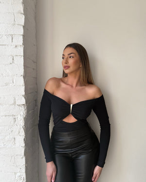 model wearing black off shoulder top and leather pants