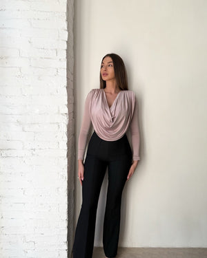 woman in draped blush top and black pants
