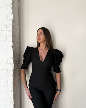 woman wearing black dress with puff sleeves